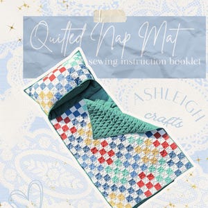 May include: A quilted nap mat sewing instruction booklet titled Quilted Nap Mat by Ashleigh crafts. The mat features a colourful patchwork pattern of red, blue, yellow, and green squares on a white background with a solid green quilted underside.