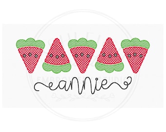 May include: An embroidered design featuring five watermelon slices in red and green, with black seeds. The word "annie" is written in cursive below the watermelons. The design is set against a white background.