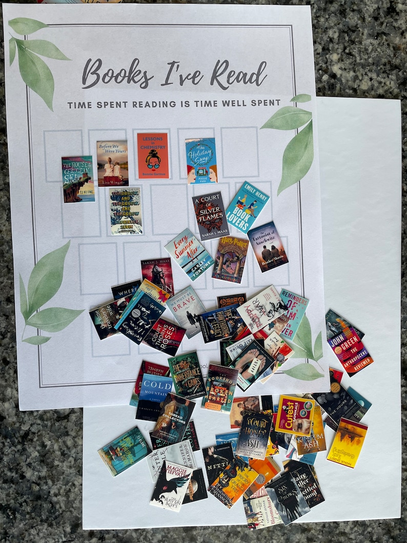 Op de afbeelding: Een wit bord met de tekst "Books I've Read" en "Time Spent Reading is Time Well Spent" bovenaan. Het bord is verdeeld in een raster met vierkanten. Elk vierkant heeft een miniatuur boekomslag erop geplaatst. De boekomslagen zijn in verschillende kleuren en genres. Er zijn ook miniatuur boekomslagen verspreid rond het bord.
