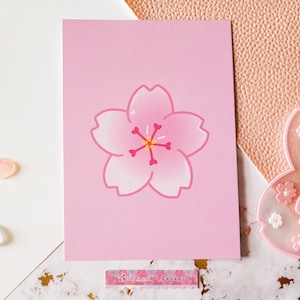 May include: A pink card with a pink cherry blossom illustration in the center. The card has the text "Better Sweet Blossom" at the bottom.