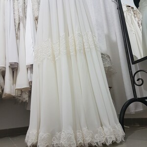 May include: A white chiffon skirt with lace trim. The skirt is gathered at the waist and has a flowing silhouette.