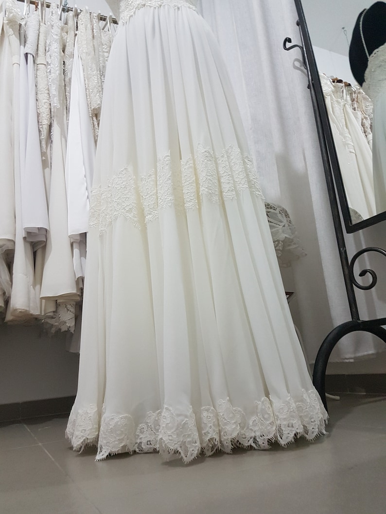 May include: A white chiffon skirt with lace trim. The skirt is gathered at the waist and has a flowing silhouette.