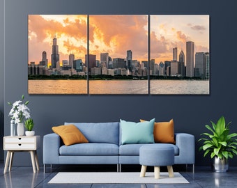 May include: A panoramic view of the Chicago skyline at sunset. The city's skyscrapers are silhouetted against a vibrant orange and pink sky, with fluffy clouds reflecting the warm light. The water in the foreground is calm and reflective, creating a mirror-like surface.