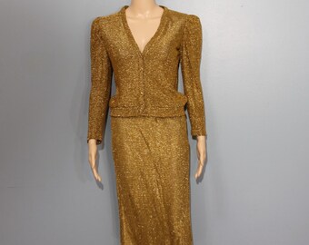 May include: A gold sparkly knit cardigan and skirt set. The cardigan has a v-neck and button closure. The skirt is a-line and knee-length.