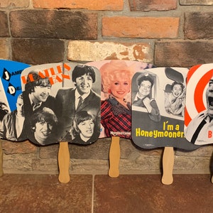 Vintage 1980s Coleccionable Celebrity Cardboard and Wood Hand Fans cada uno se vendió por separado Beatles, Dolly Parton, James Dean, The Honeymooners