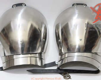 May include: A pair of silver metal shoulder armour plates with a black leather strap. The armour is made of multiple layers of metal and has a rounded shape. The text "Honour Kraft" is visible on the right plate.