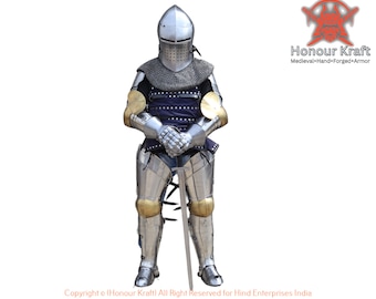 May include: A full suit of medieval armour in silver with gold accents. The armour includes a helmet, breastplate, gauntlets, and leg armour. The knight is holding a sword in his hands. The image includes the text "Honour Kraft Medieval+Hand+Forged+Armour" and "Copyright o (Honour Kraft) All Right Reserved for Hind Enterprises India".