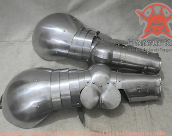 Könnte beinhalten: Ein Paar silberfarbene mittelalterliche Handschuhe aus Metallplatten mit einem Scharniergelenk am Ellbogen. Die Handschuhe sind für die linke und rechte Hand konzipiert und werden auf einer hellgrauen Oberfläche präsentiert.