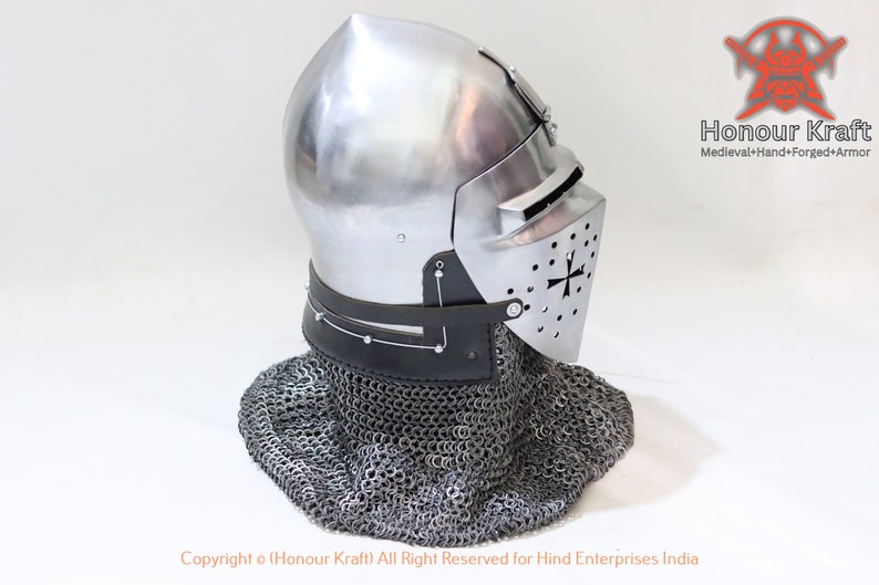 May include: A silver helmet with a visor and a chainmail coif. The helmet has a cross on the visor and is made of metal. The helmet is on a white background.