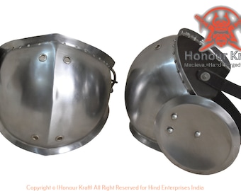 May include: A pair of silver metal knee guards with straps. The knee guards are designed to protect the knees during combat or other activities.