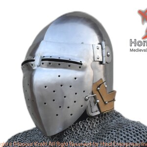May include: A medieval helmet with a visor and a chainmail coif. The helmet is made of steel and has a brown leather lining. The helmet is hand-forged and has a textured surface.