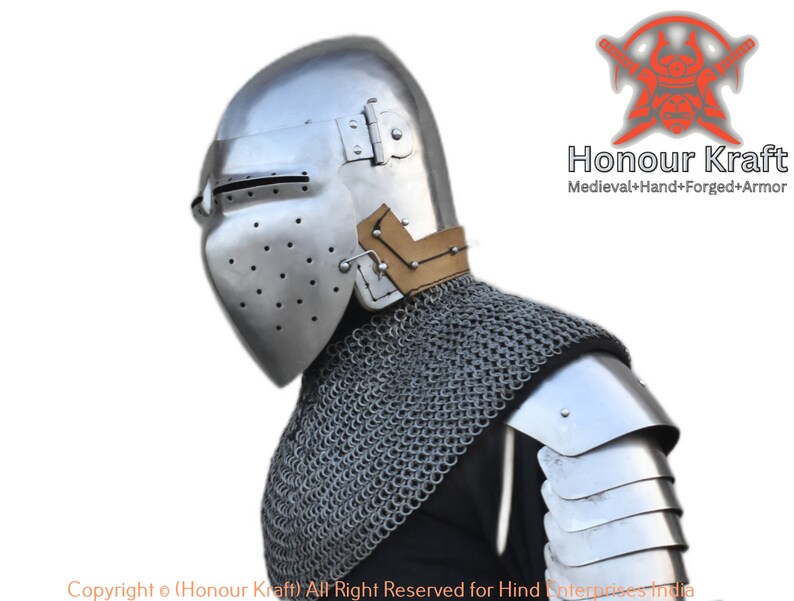 May include: A silver helmet with a visor and a brown leather strap. The helmet is worn by a person wearing chainmail and a silver shoulder piece. The text "Honour Kraft Medieval+Hand+Forged+Armor" is visible in the upper right corner of the image.