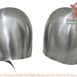 Puede incluir: Un par de protectores de codo de metal plateado, también conocidos como couters, para la recreación medieval o LARP. Los couters están hechos de acero y tienen una forma redondeada. Están diseñados para proteger el codo de los golpes.