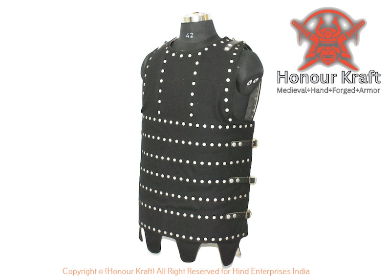 May include: A black leather vest with silver rivets and buckles. The vest has a pointed bottom and is designed to look like medieval armor. The text "Honour Kraft" is visible in the image.