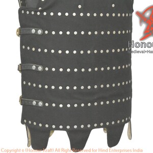 May include: A black leather cuirass with silver rivets and leather straps. The cuirass has a pointed bottom and is decorated with a row of silver rivets around the bottom edge.