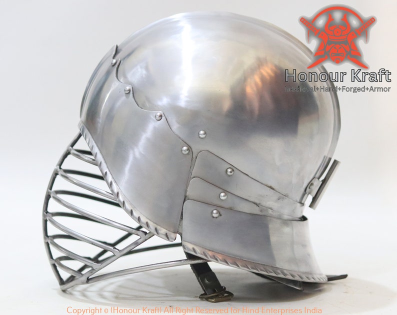 Op de afbeelding: Een zilveren helm met een vizier en een nekbeschermer. De helm is gemaakt van metaal en heeft een gladde, gepolijste afwerking. De helm is een type middeleeuwse armor.
