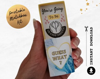Puede incluir: Un anuncio tipo caja de cerillas con el texto "You're Going To Be Grandparents!" y "Guess What?" en un diseño en forma de corazón. La caja tiene una combinación de colores amarillo y azul, con un círculo dorado que dice "Printable Matchbox Kit".