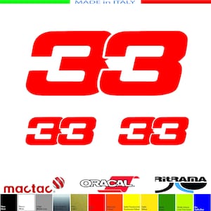 Può includere: Decalcomanie da corsa rosse numero 33. Le decalcomanie sono in un carattere grassetto e a blocchi. L'immagine mostra le decalcomanie in diverse dimensioni e orientamenti. L'immagine include anche una cartella colori con vari colori e i marchi mactac, Oracal e Ritrama.