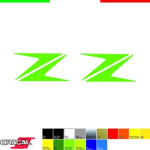 Può includere: Due adesivi a forma di Z verde neon su sfondo bianco. Gli adesivi sono angolati e sembrano essere per uso automobilistico o decorativo. L'immagine include anche una tabella colori e il marchio "ORACAL".