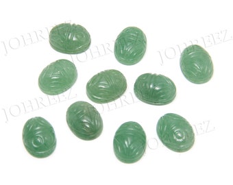Pode incluir: Dez cabochões ovais verdes com um design de escaravelho esculpido. Os cabochões medem aproximadamente 2,5 cm de comprimento e 1,25 cm de largura.