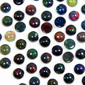 May include: Assortment of round, iridescent opal cabochons in various colors, including black, green, red, and blue. The cabochons are approximately 10mm in diameter and have a smooth, polished surface.