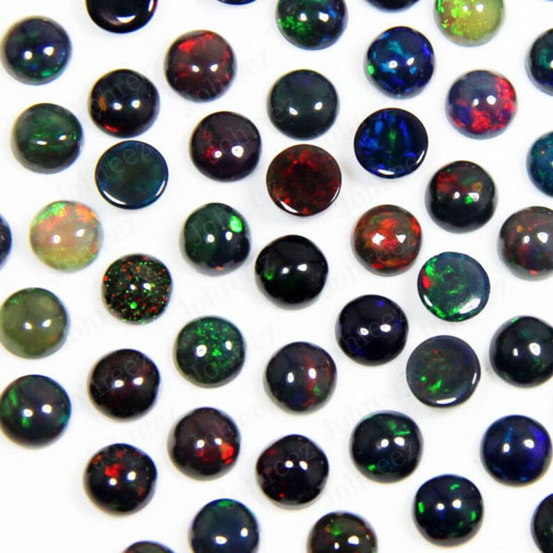 May include: Assortment of round, iridescent opal cabochons in various colors, including black, green, red, and blue. The cabochons are approximately 10mm in diameter and have a smooth, polished surface.