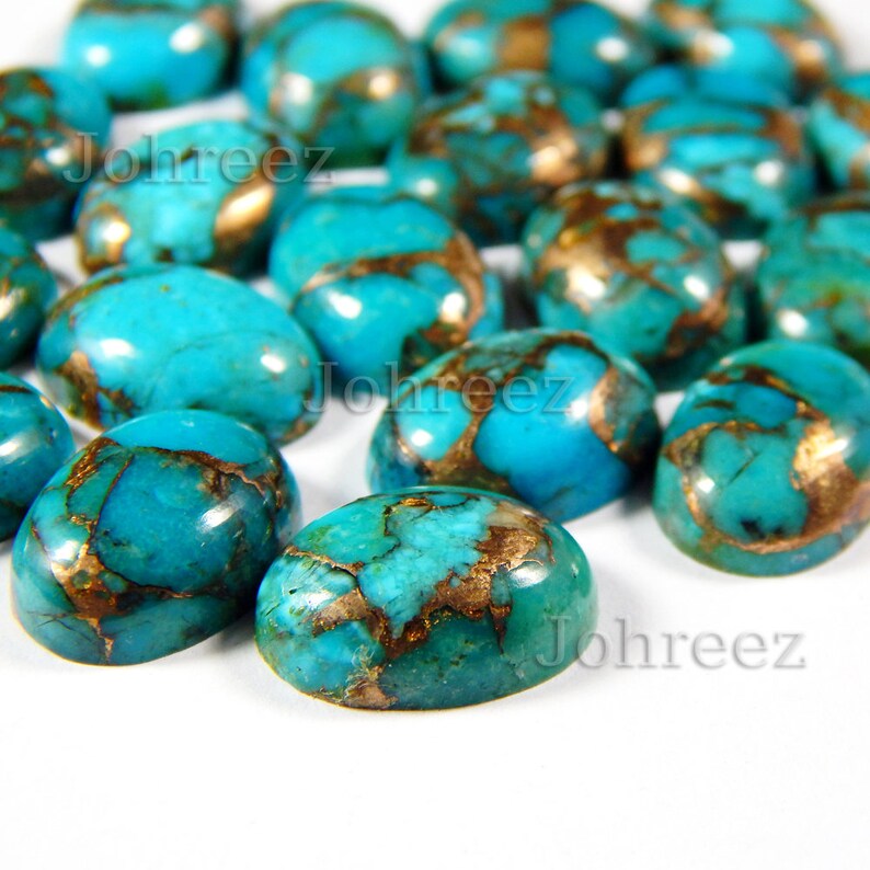 Puede incluir: Una colecci&oacute;n de cabujones ovalados de turquesa con inclusiones de cobre. Las piedras son de un color azul verdoso vibrante y tienen un acabado liso y pulido.