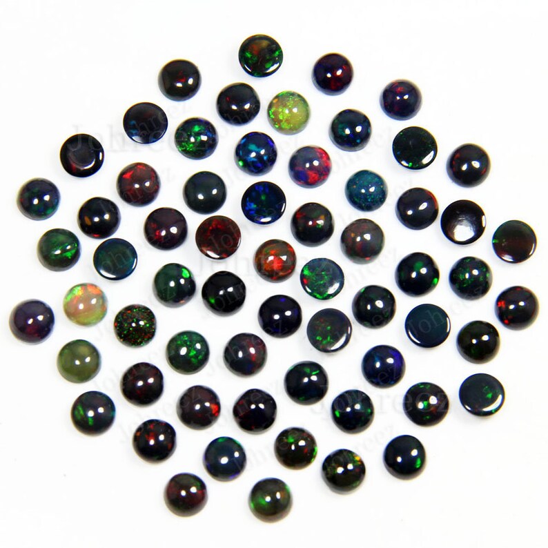 May include: A collection of 50 round black opal cabochons, each with a different iridescent color display. The opals are approximately 6mm in diameter and have a smooth, polished finish.