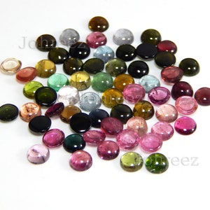 May include: Assortment of round, cabochon cut gemstones in various colors, including pink, green, brown, and black. The gemstones are approximately 6mm in diameter and are ideal for jewelry making.