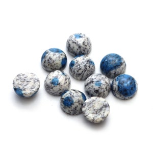 May include: A collection of ten blue and white cabochon gemstone beads. The beads are round and have a speckled pattern.