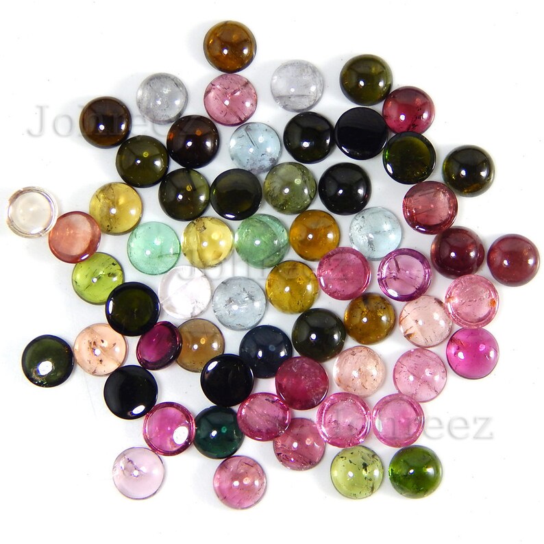 May include: Assortment of round, cabochon cut gemstones in various colors, including pink, green, blue, brown, black, and clear. The gemstones are approximately 6mm in diameter.