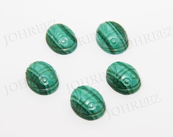 Pode incluir: Seis cabochões de malaquita verde esculpidos com desenhos de escaravelho. Os cabochões são de forma oval e têm um acabamento liso e polido.