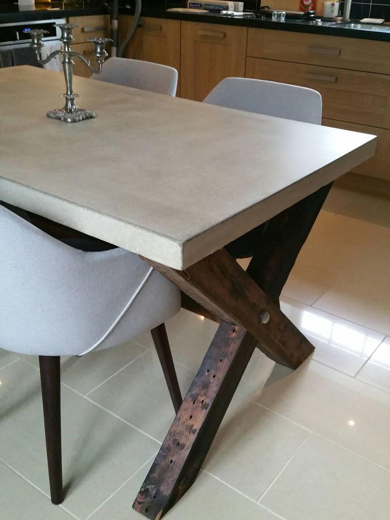 Mesa de comedor de hormigón con patas de madera recuperada por Kelham