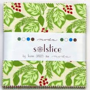 May include: A fabric square with a green and white pattern of leaves and red berries. The fabric is labeled "Solstice by Karen Scrain for Moda".