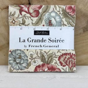 May include: A stack of fabric squares with a floral pattern in red, blue, and beige. The fabric is labeled "La Grande Soirée by French General". The squares are held together with a white band.