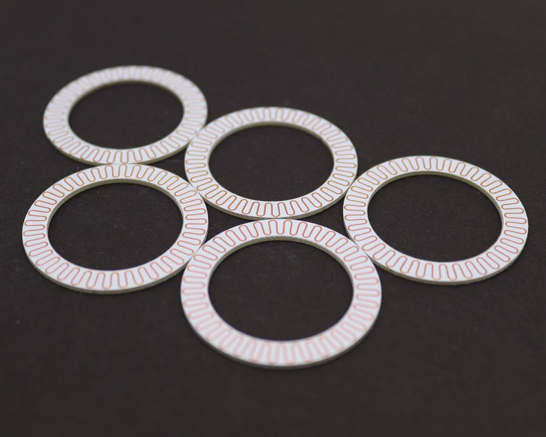 May include: Six white circular discs with a red patterned border. The discs are arranged in a circular pattern on a black background.