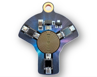 May include: A close-up of a circuit board with a unique shape. The board is primarily dark blue with a gold-colored circular component in the center. Several small black components are arranged around the gold circle.