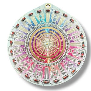 May include: A circular, white circuit board with a colorful, abstract design in the center. The design features a spiral pattern with gold accents and lightning bolts. The board is surrounded by a ring of red and white LED lights.
