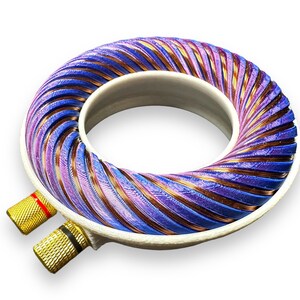Peut inclure: Un objet rond blanc imprim&eacute; en 3D avec une bobine de fil de cuivre et violet enroul&eacute;e autour. La bobine est connect&eacute;e &agrave; deux bornes dor&eacute;es.