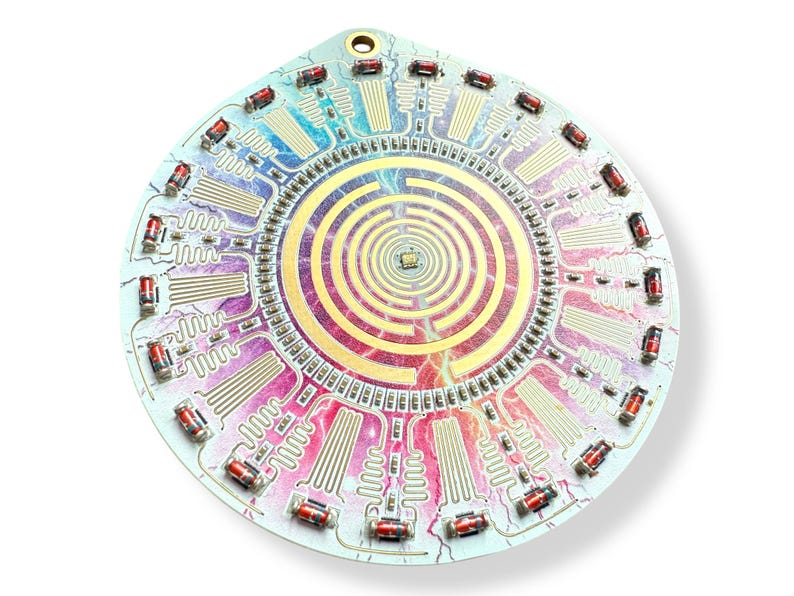 May include: A circular circuit board with a colorful, swirling pattern and a central spiral design. The board is surrounded by a ring of small, red electronic components.