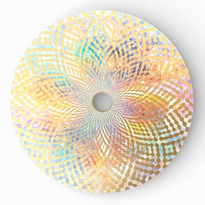 Può includere: Un oggetto decorativo rotondo con un foro centrale. La superficie presenta un motivo geometrico ripetuto in tonalità oro, giallo, blu e rosa, creando un effetto cangiante e iridescente. L'oggetto è posto su uno sfondo bianco.