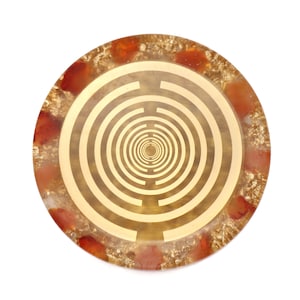 May include: A round, gold-colored, crystal-infused, energy healing disc with a concentric circle pattern. The disc is surrounded by a border of red and gold.