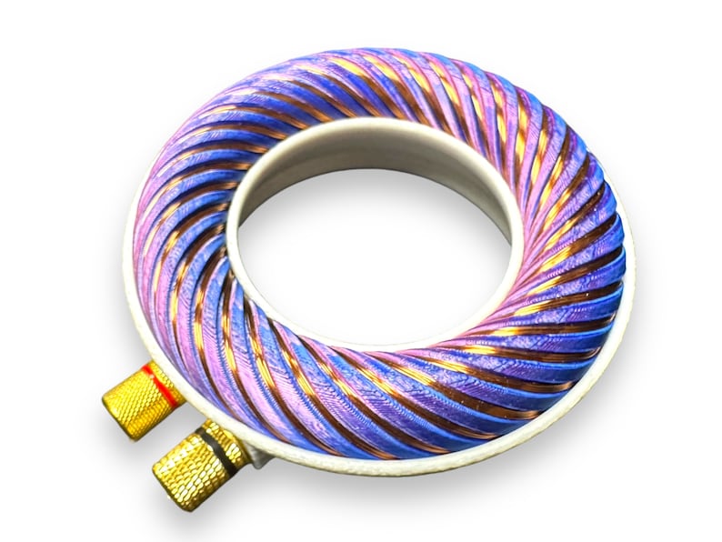 Peut inclure: Gros plan d'une bobine de couleur violette et cuivre avec des connecteurs dor&eacute;s. La bobine est enroul&eacute;e en spirale et est probablement utilis&eacute;e dans un appareil &eacute;lectronique.