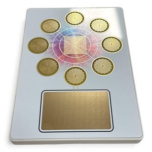 May include: A rectangular, light grey device with a gold-coloured rectangular panel at the bottom. The device features a central geometric design with eight gold spiral circles surrounding it. The design has a colourful, rainbow-like background.