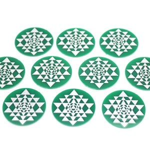 May include: Ten green round coasters with a white geometric design. The design is a repeating pattern of triangles.