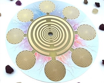 May include: A circular, gold-colored spiritual tool with a central labyrinth design and eight surrounding spiral patterns. The background features a blue and pink celestial design with scattered gemstones.