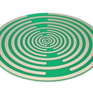 May include: A circular green circuit board with concentric rings of gold-colored conductive traces.