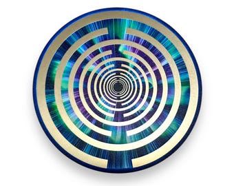 May include: Circular artwork with a blue, gold, and iridescent design. The piece features concentric circles with a maze-like pattern in shades of blue, green, and purple. The outer edge is a deep blue, and the inner circles have a gold border.