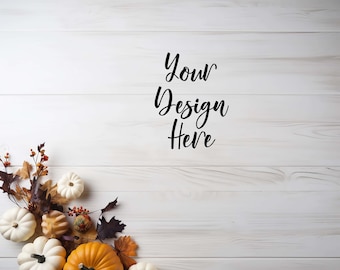 May include: White wood background with the text "Your Design Here" in black.  The bottom left corner of the image features a cluster of fall-themed decorations, including white pumpkins, orange pumpkins, fall leaves, and berries.