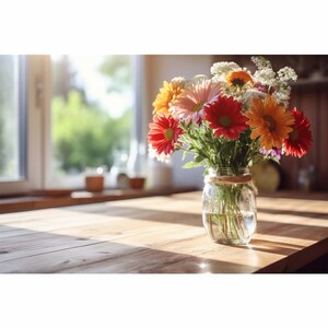 May include: A bouquet of colourful flowers, including pink, red, orange, and white, arranged in a clear glass jar with a brown twine accent. The flowers are sitting on a wooden table with natural light streaming in from a window.
